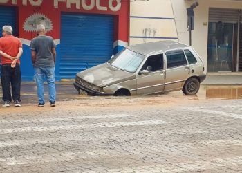 Carro afunda em buraco encoberto por água no Centro de Valadares