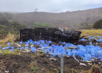 Caminhão carregado de água mineral capota na BR-259 e deixa duas pessoas gravemente feridas